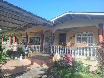 Front exterior of Caribbean style house with garden porch and arches in Bugaba Panama