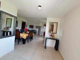 Dining area connecting to hallway with mirror and artwork in furnished Bugaba rental home
