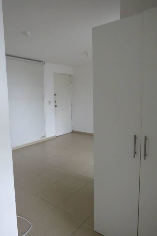 Minimalist apartment entry with closet, bright white walls and tiled floors at PH Mystic Hills 2nd Phase Panama