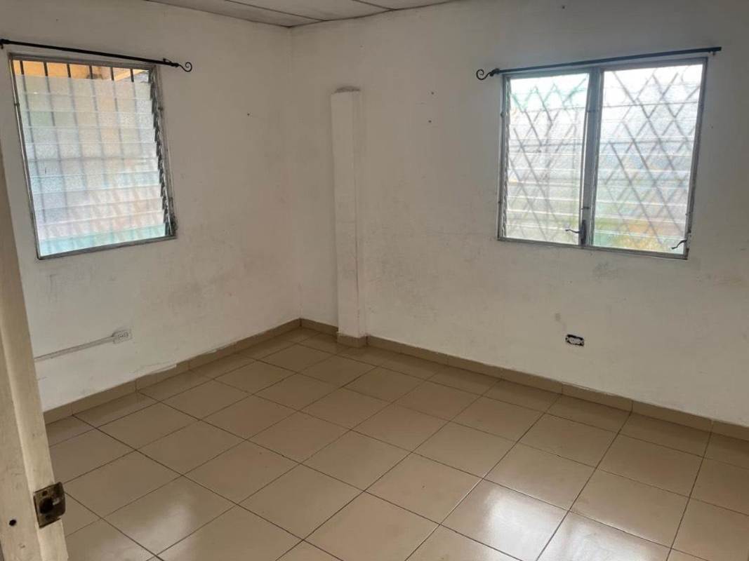 Second bedroom with tile flooring, barred windows, white walls near Metro Paraíso Panama