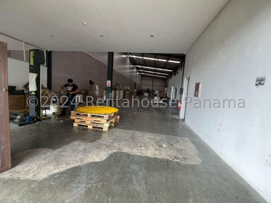 Functional office area with multiple desks, AC, white walls in Tocumen warehouse Panama