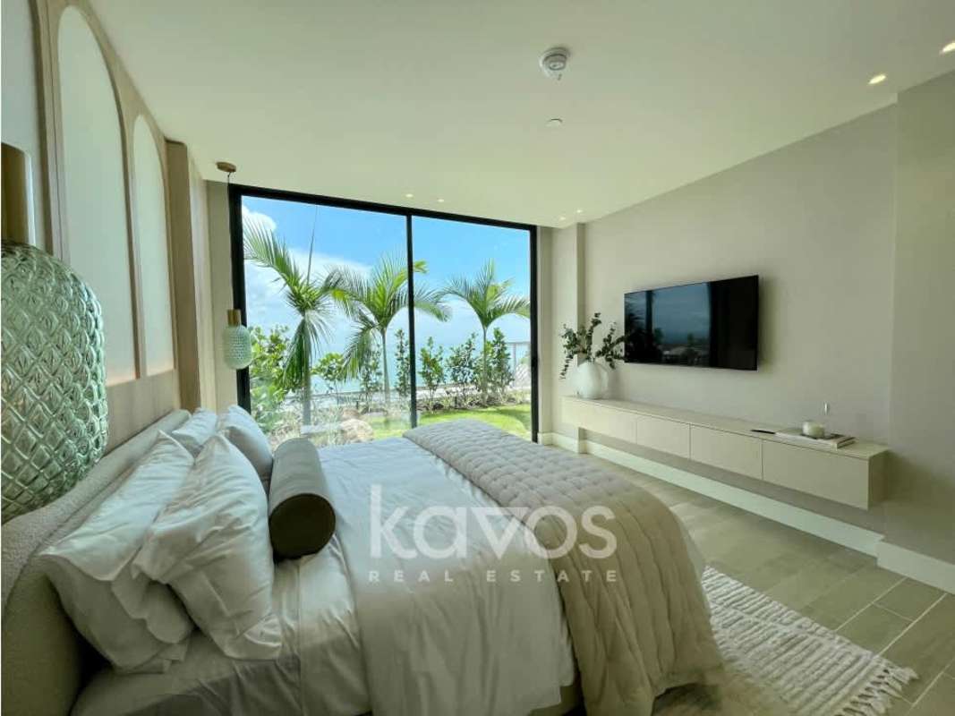 Bright living and dining area with floor-to-ceiling windows overlooking garden patio at Ocean Reef Island Panama