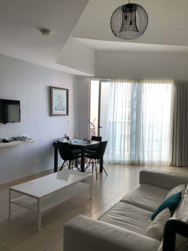 Living room with dining space and balcony access in PH Ocean Club Punta Pacífica Panama