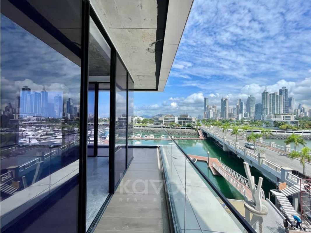 Glass facade contemporary waterfront condo tower on Ocean Reef with marina backdrop in Panama City