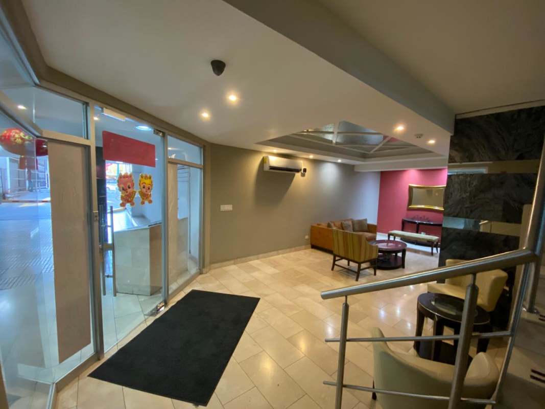 Elegant lobby with glass entrance doors sofas and lighting at PH Torre 88 Panama City