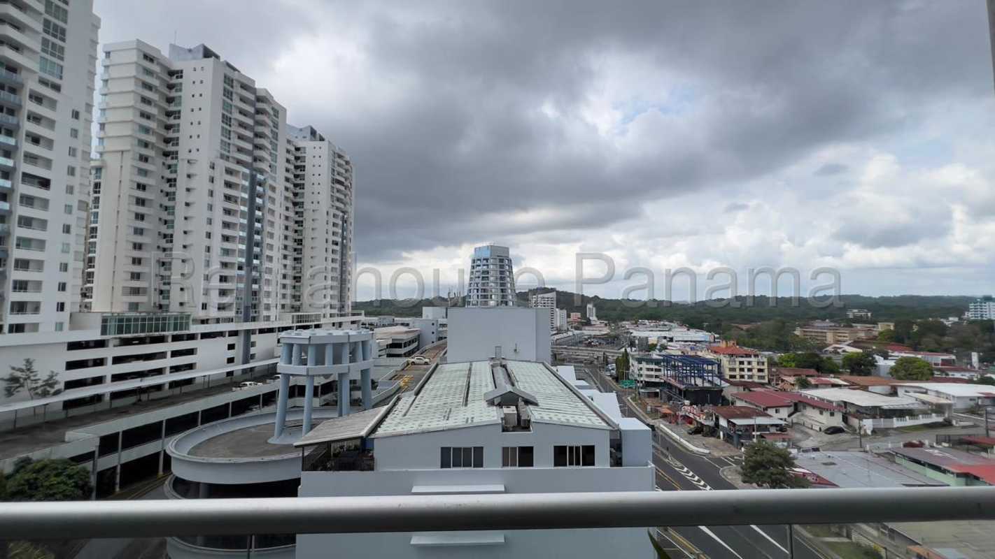 Bright living room with balcony access, gray sectional sofa, AC and city view in PH Vivendi Green Edison Park