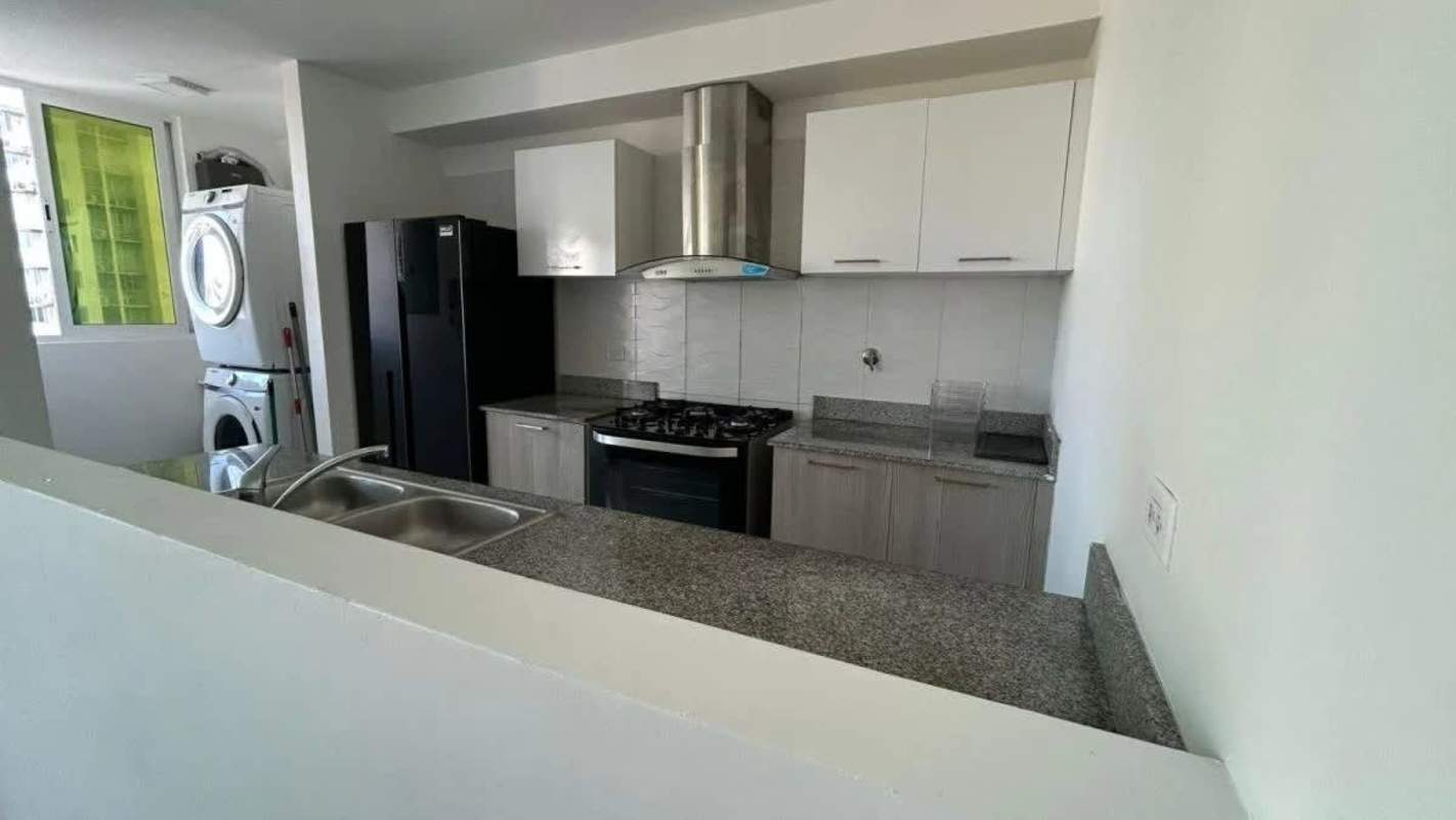 Kitchen view with granite countertops, washer dryer, refrigerator in apartment for rent PH Metropolitan Park Panama City