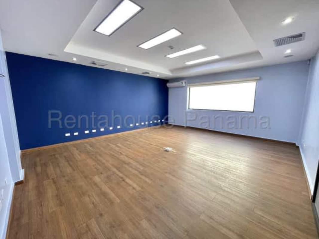 Modern empty office with wooden floors, large window, drop ceiling lighting in Costa del Este commercial building