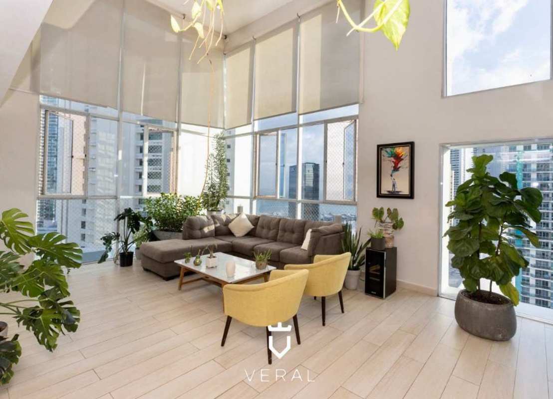 Double-height living room with large floor-to-ceiling windows and panoramic city view at PH Blue Park Bella Vista