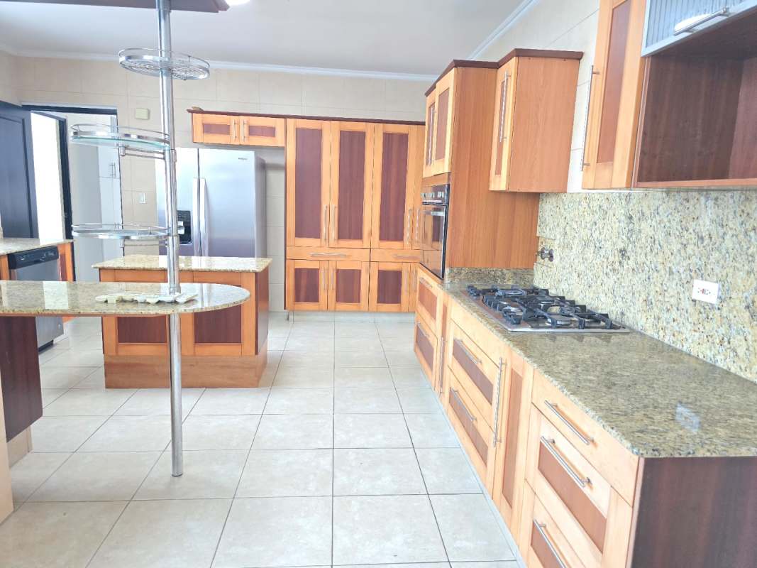Spacious kitchen granite island wood cabinetry built-in gas stove PH Ocean Drive