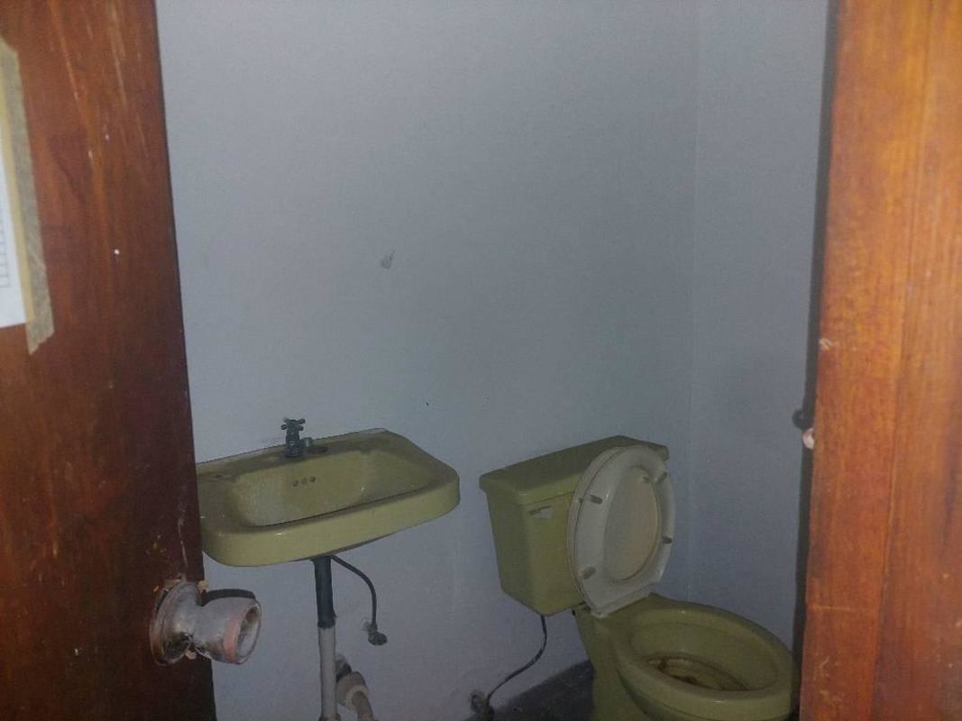 Basic industrial bathroom with sink and toilet inside warehouse in Panama