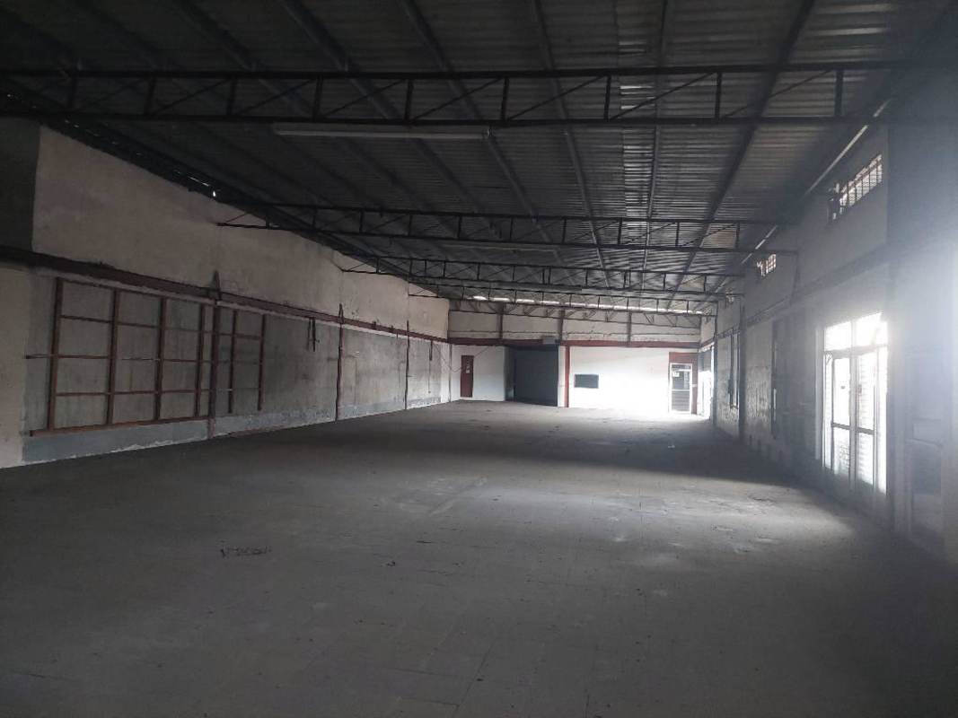 Industrial warehouse interior with tall ceiling and loading door in Panama City