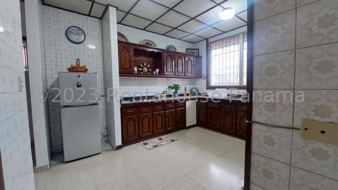 Spacious traditional kitchen with wood cabinets, refrigerator, double oven and natural light