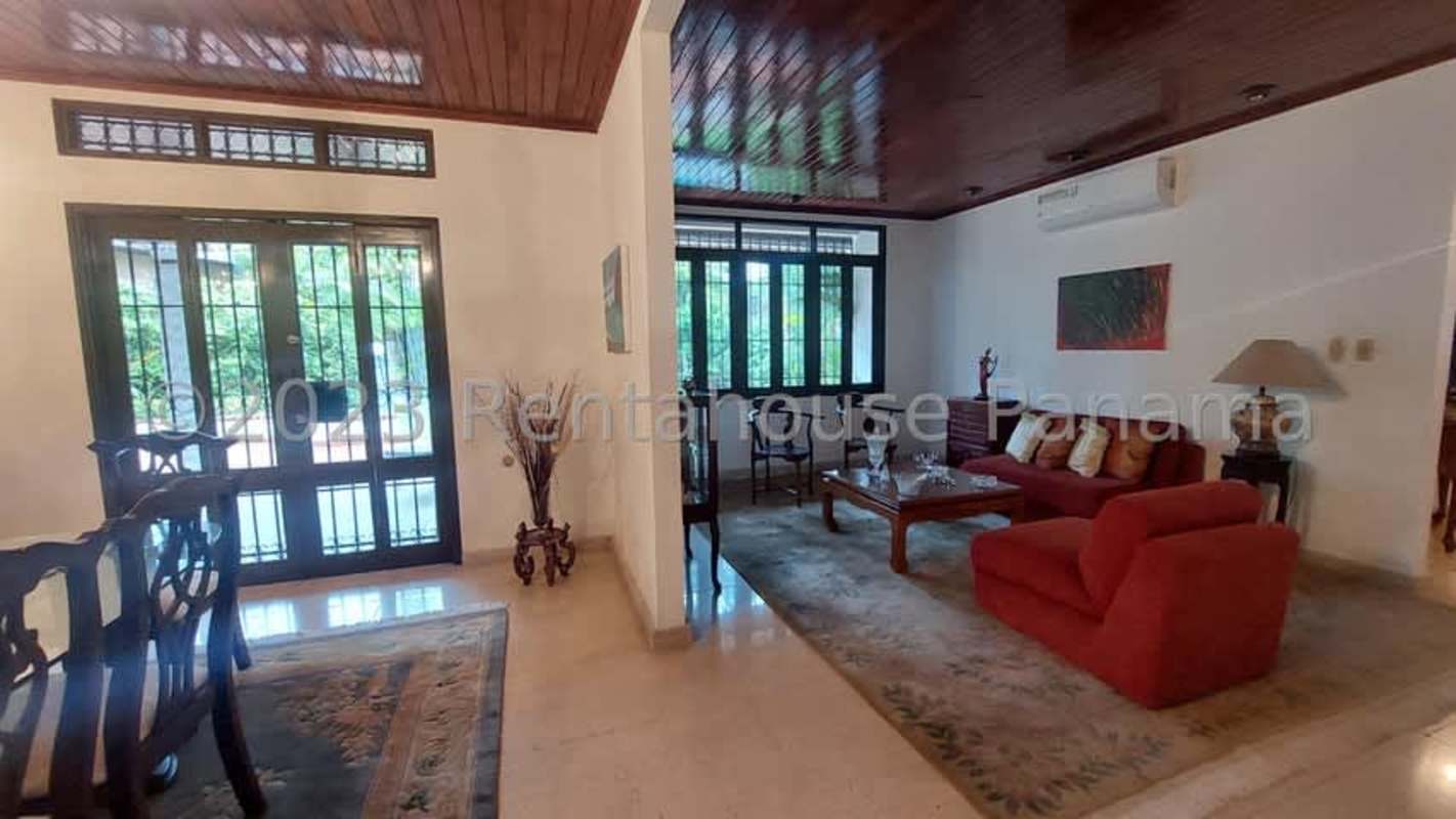 Spacious covered patio with ceiling fans, hammock and outdoor furniture facing pool