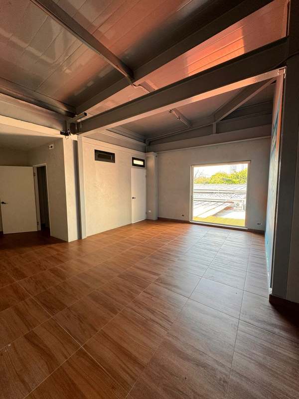 Open plan interior space with wood tile floors ceiling beams Plaza Corner 68 Panama City