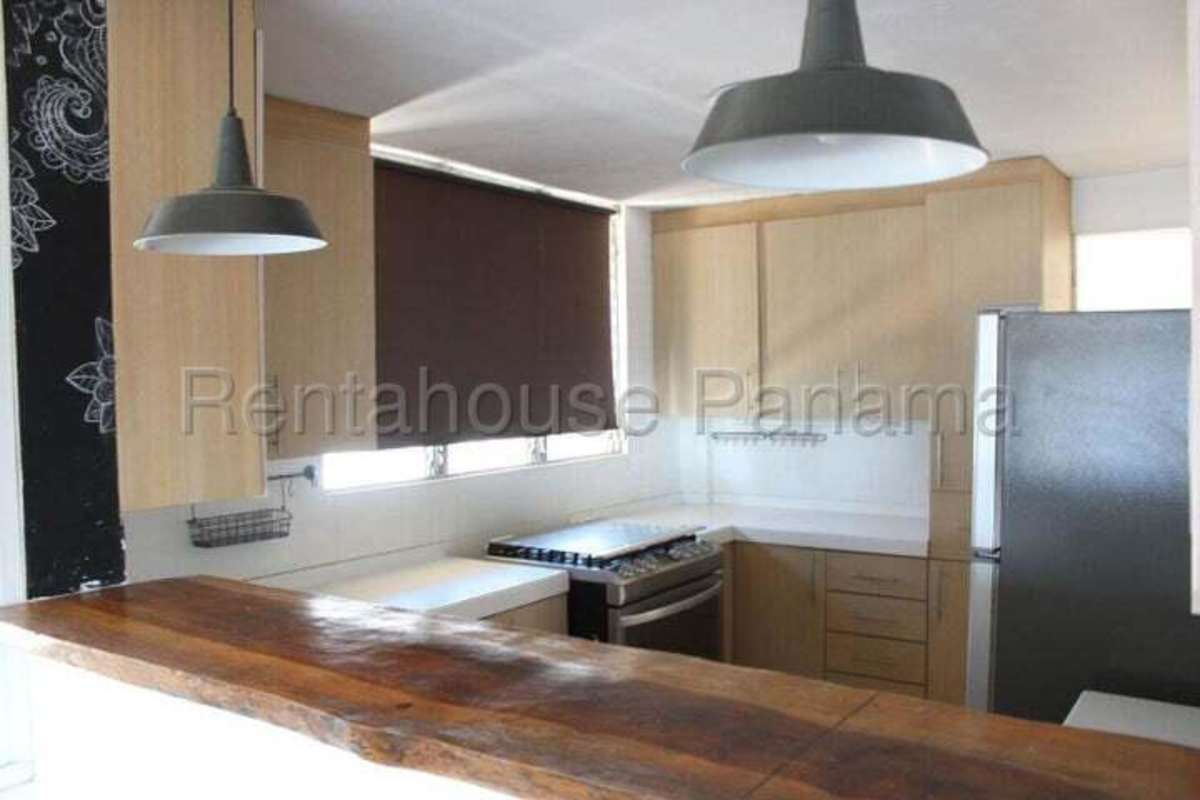 Kitchen space with wooden cabinets and tile backsplash in PH Obarrio Central Panama City