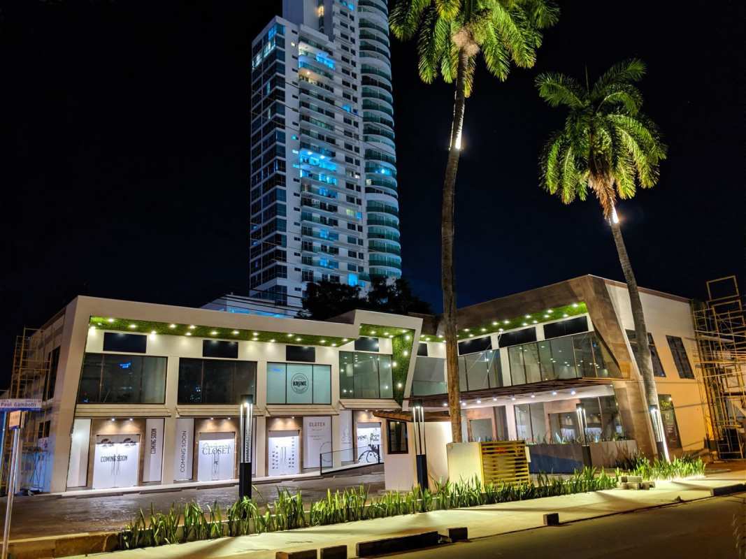 Commercial plaza exterior with night illumination and palm trees Panama City