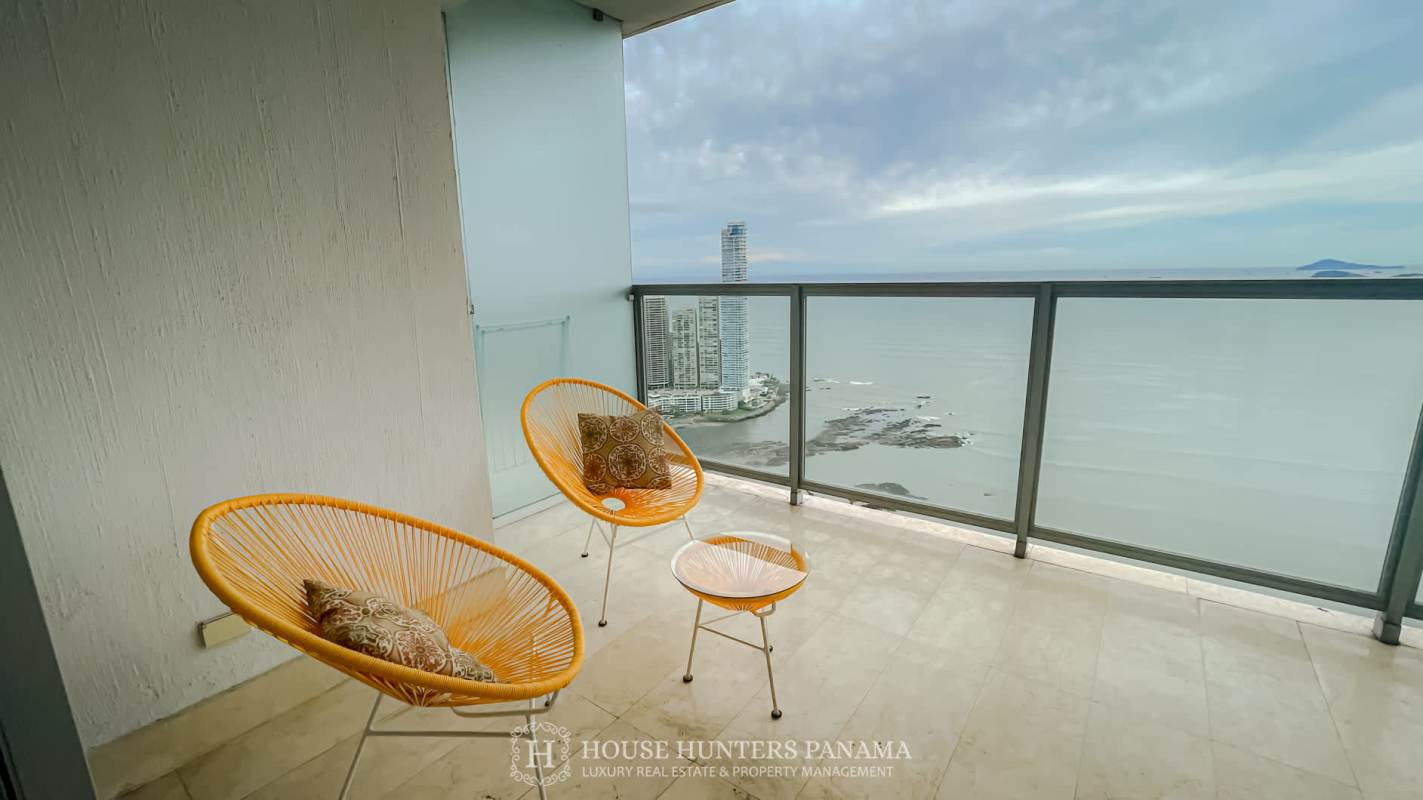 Open kitchen with stainless steel fridge, island counter and modern cabinets in Yoo Panama condo