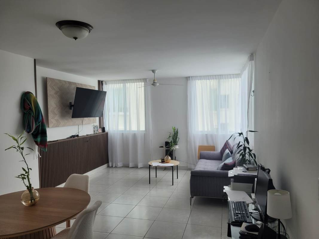 Living room with mounted TV, large window, dining space Edison Park Panama rental