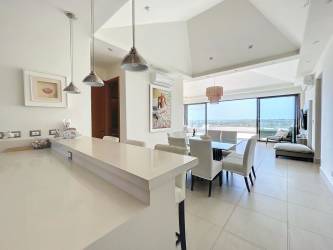 Bright modern kitchen with breakfast bar and dining area overlooking Pacific Ocean at CasaMar