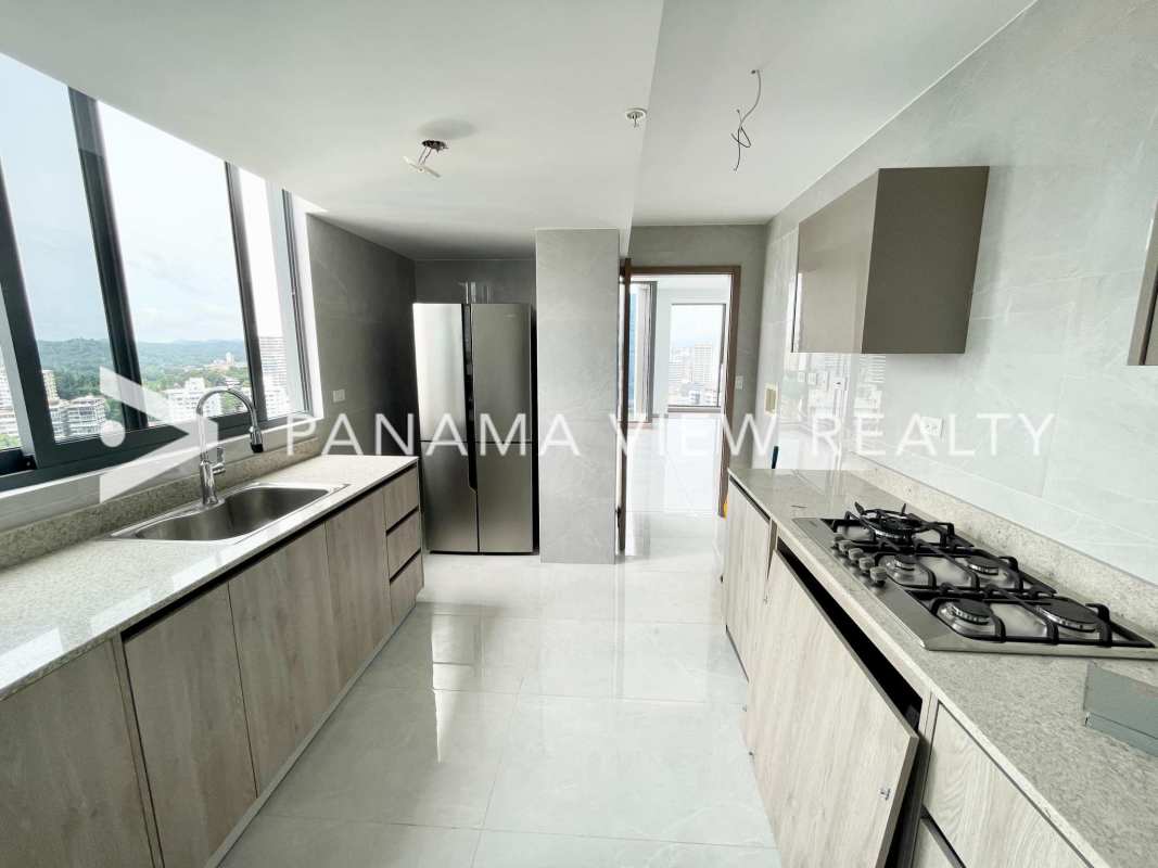 Bright penthouse living room with double height ceiling, marble floors and floor-to-ceiling ocean view windows on Avenida Balboa Panama City