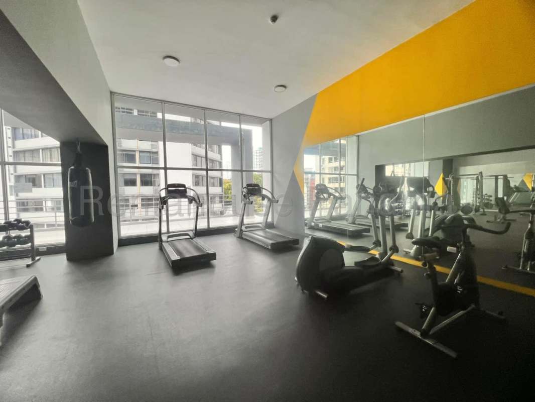 Modern apartment gym with weight equipment, cardio machines, mirrored wall in PH Cangrejo Loft Panama
