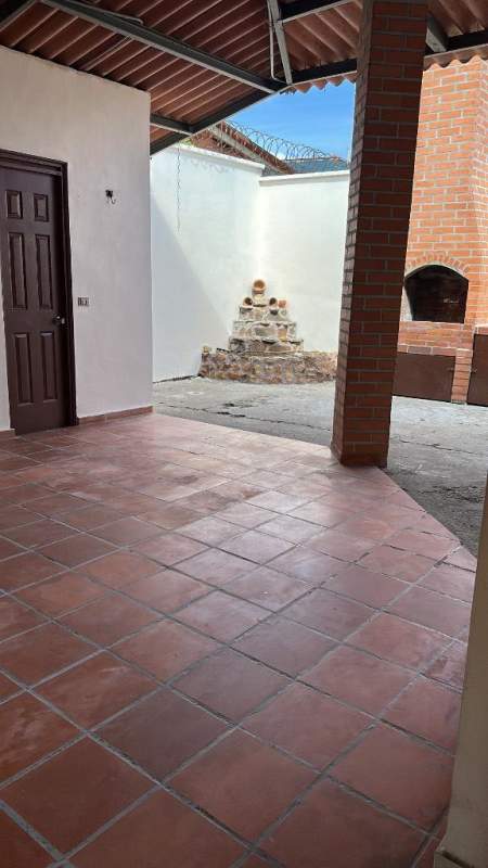 Indoor dining area with arched window, exposed beams and bar nook in house for sale Brisas del Golf