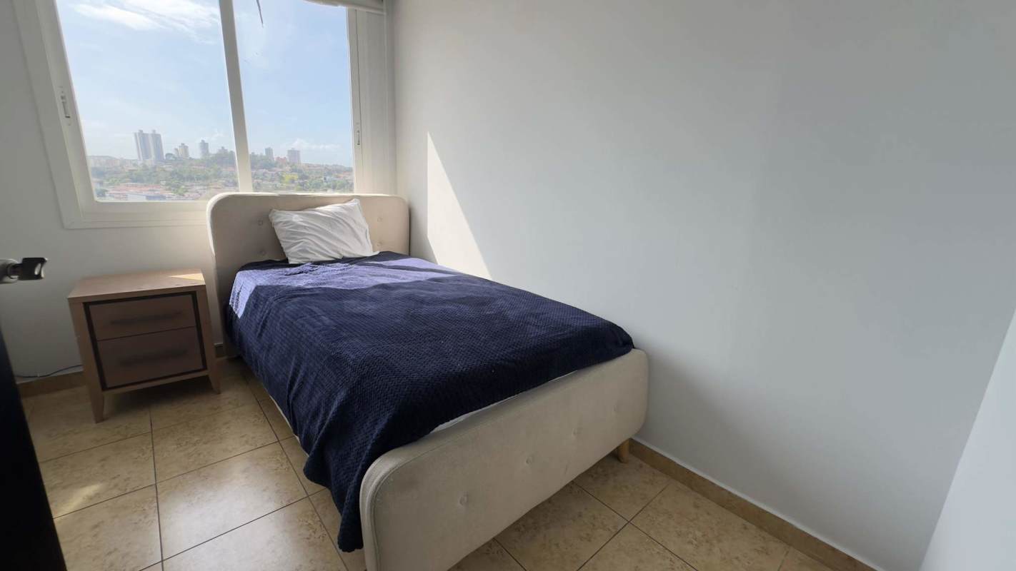 Minimalist bedroom with large window and skyline view in Elevation Tower Panama rental apartment