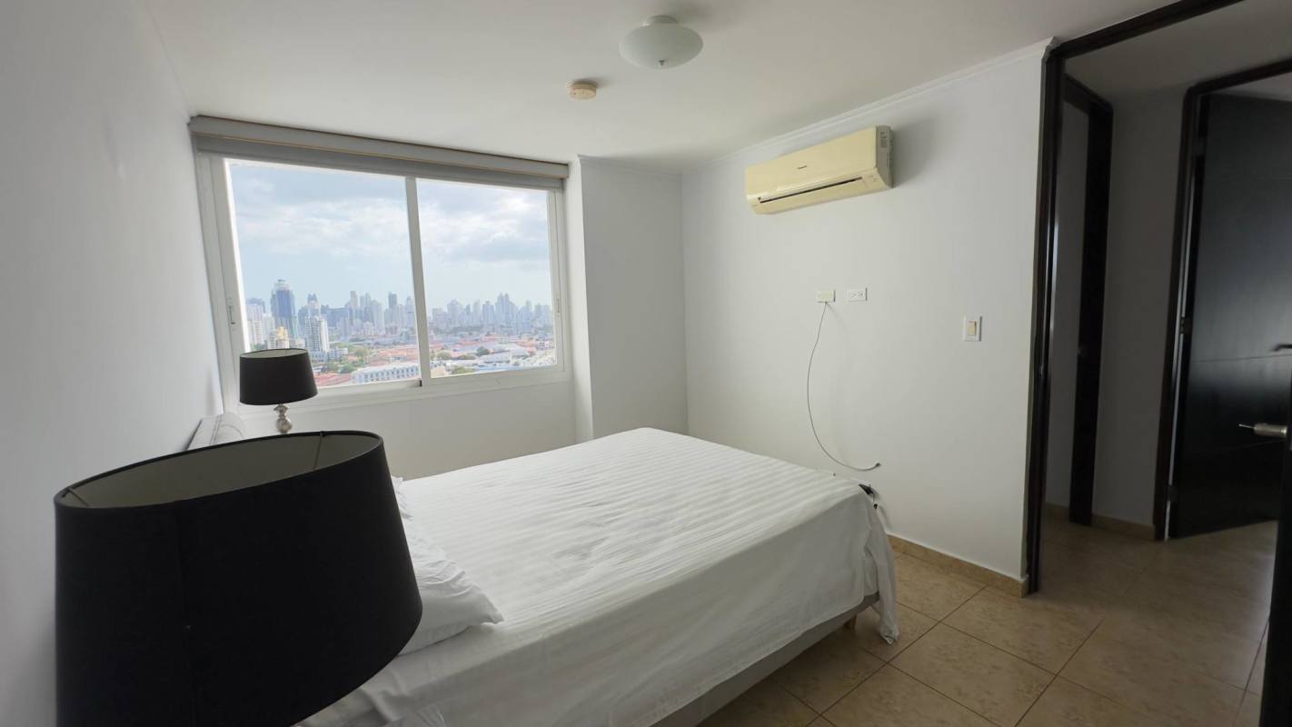 Modern bedroom with large window overlooking city skyline in Elevation Tower Panama