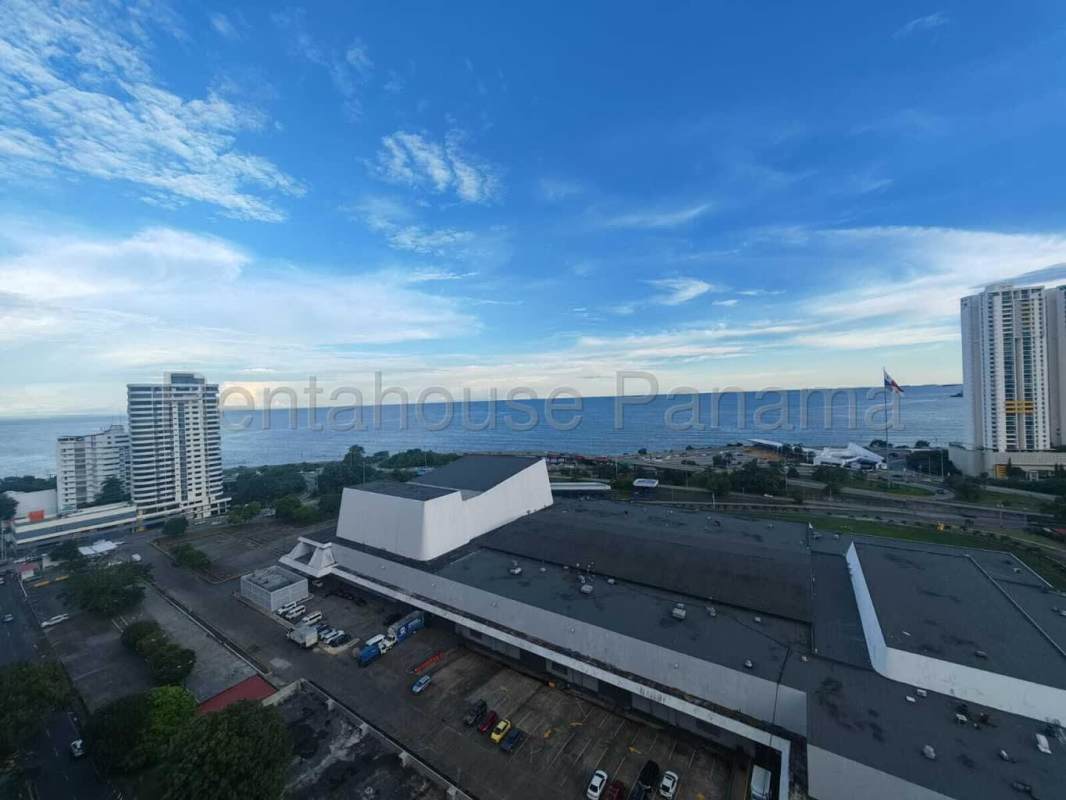 Balcony in high-rise condo with glass railing and ocean city views at PH Serenity Panama