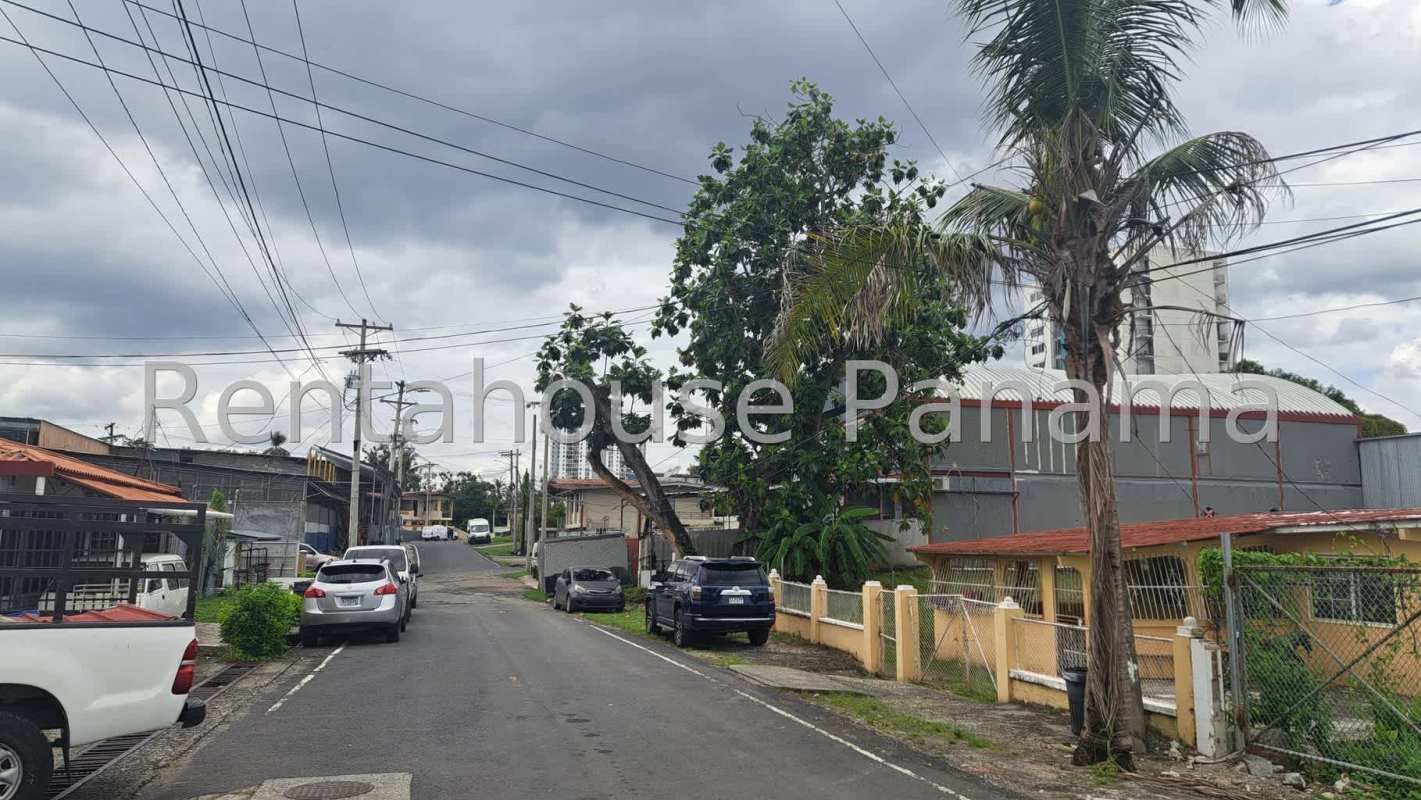 View of empty fenced lot with surrounding workshops warehouses in Parque Lefevre Panama