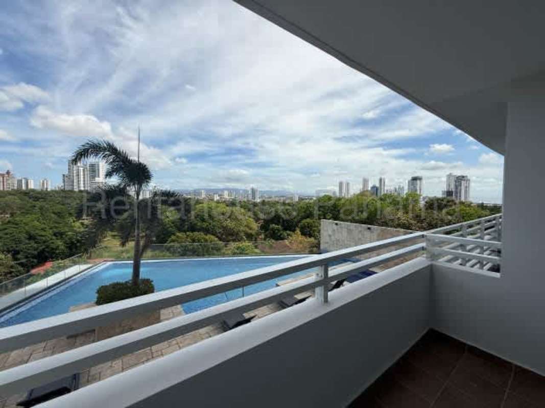 Kitchen with island bar, white cabinetry, porcelain floors in Panama condo PH San Francisco Central