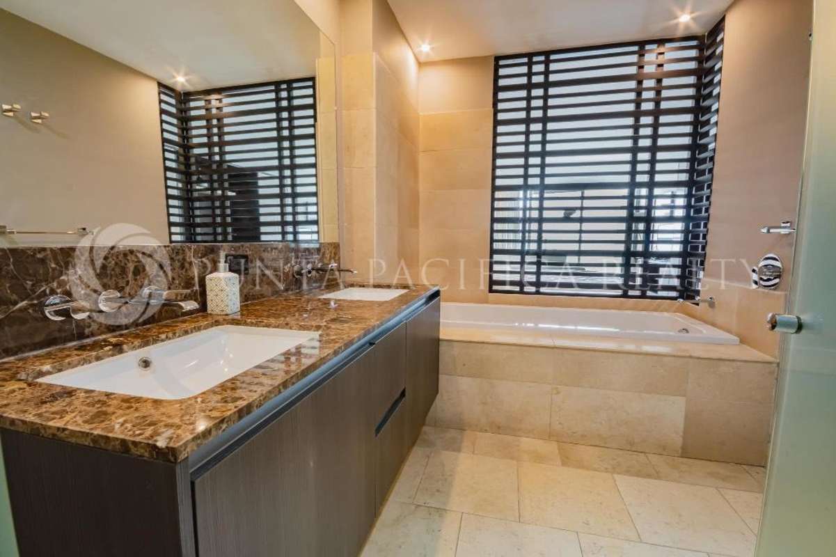 Bathroom with double marble sink, bathtub, neutral tones at The Ocean Club Panama