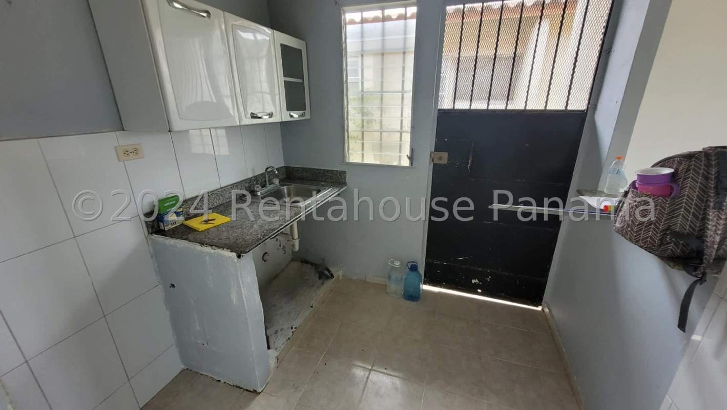 Functional kitchen granite counters white cabinets window bars Pacora Panama