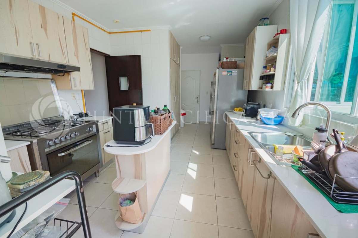 Kitchen with cabinets, stove, double sink, beige cabinetry PH Bahia Esmeralda Panama City