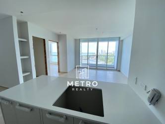 Modern apartment living room with glass doors opening to ocean view balcony in Royal Palm Gorgona Panama