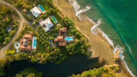 White stucco, terracotta roof Mediterranean villa lush landscaping in Playa Los Destiladeros Pedasi Panama