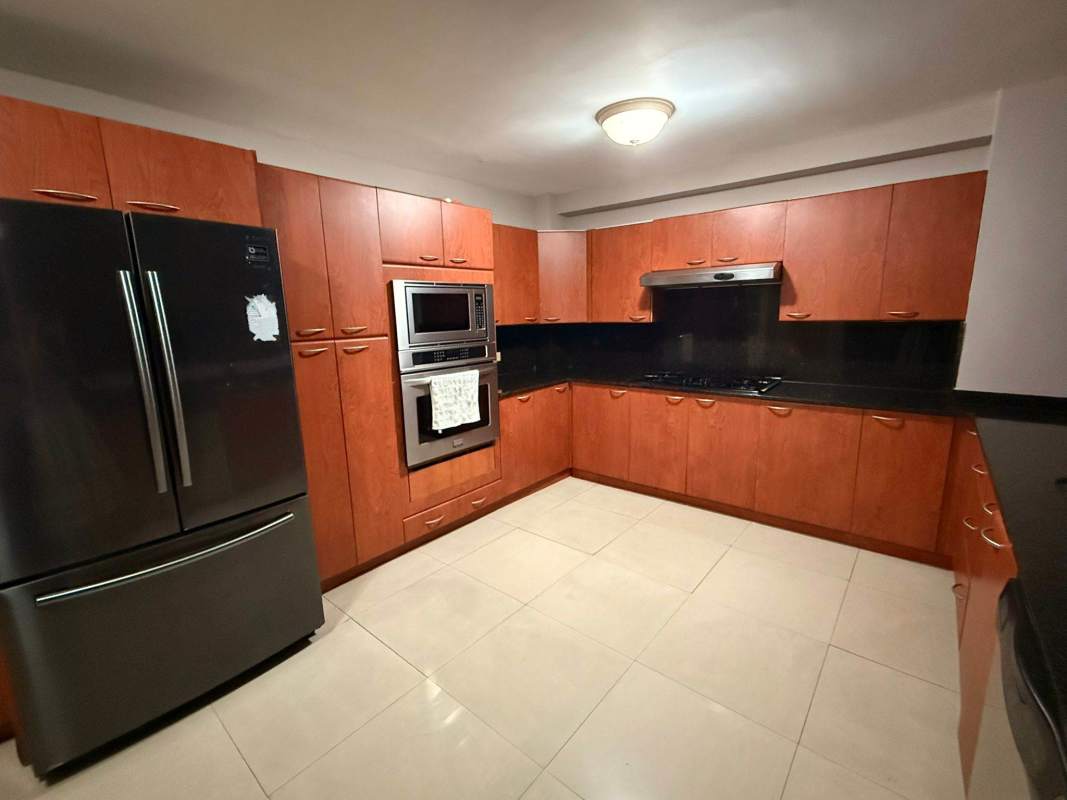 Spacious tiled living room with large windows overlooking Panama City skyline