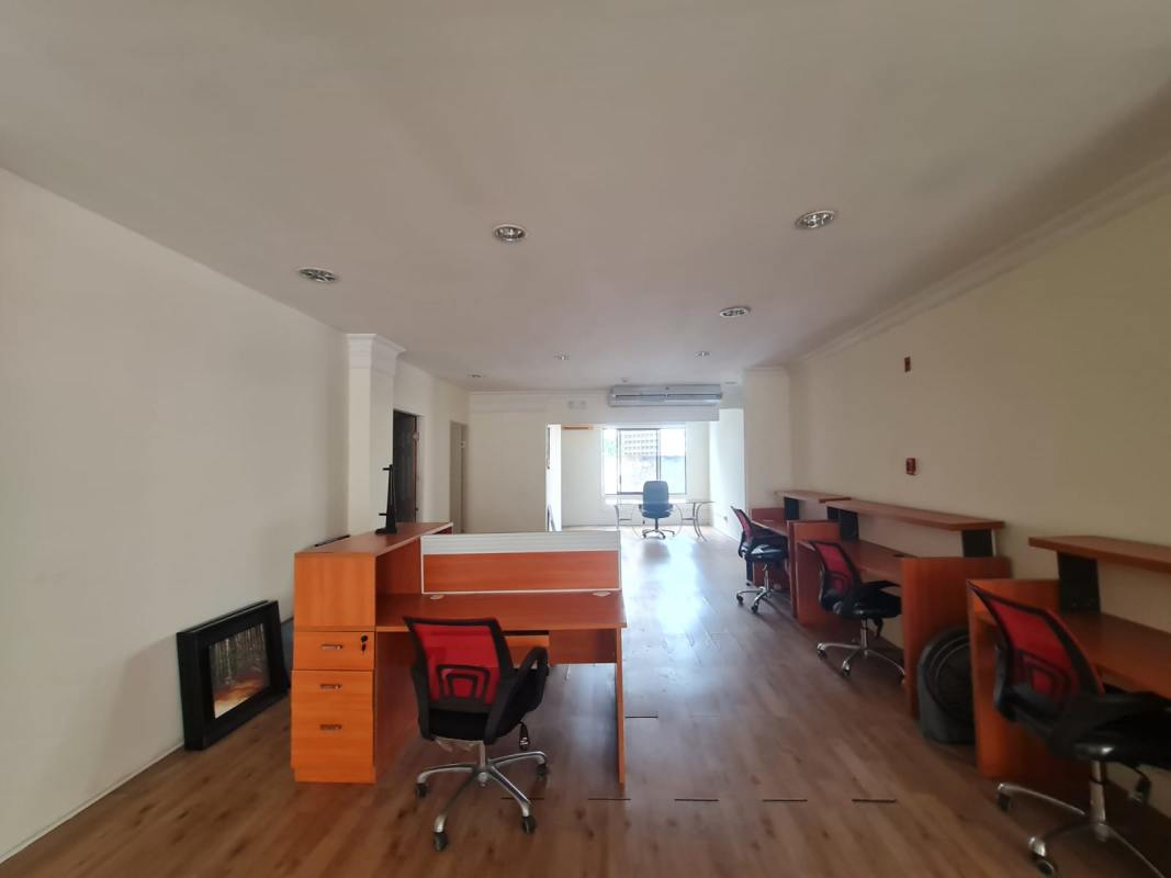 Modern workspace with wooden desks, red chairs, wood floors, PH Obarrio Center near Calle 50 Panama City