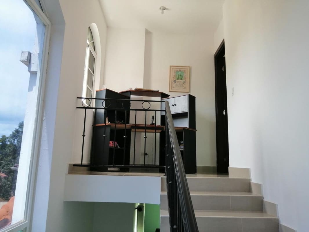 Bright stairwell with decorative railing, arched windows and landing area green field home