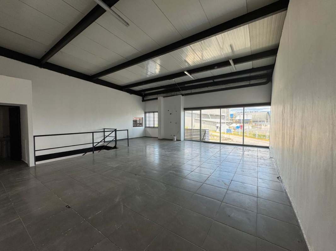 Spacious commercial interior with tiled flooring, large windows, mezzanine and open plan layout