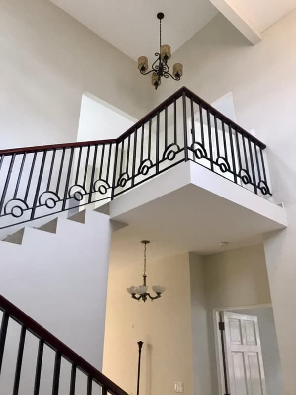 Grand entrance foyer with iron staircase and chandeliers Clayton Village house
