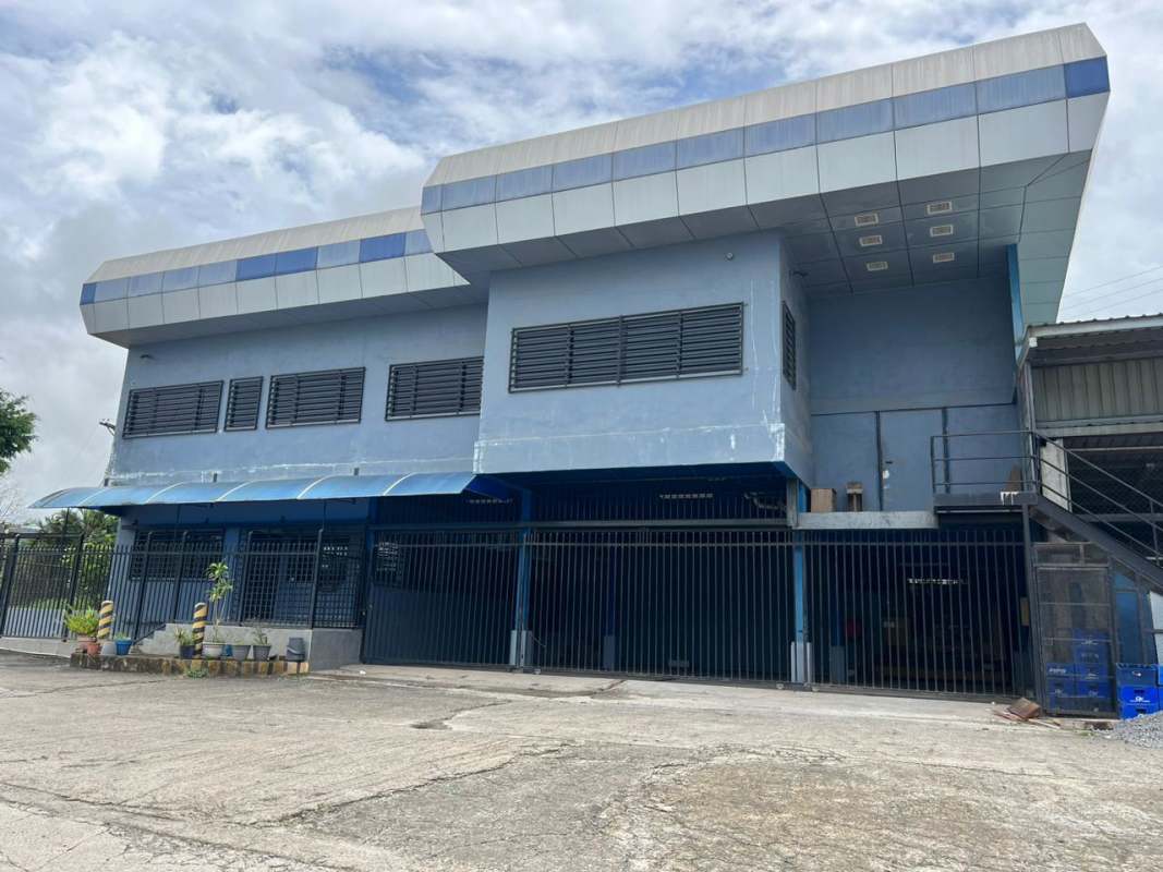 Industrial building with metal grills, external stairs, large gates in Las Mañanitas Panama City