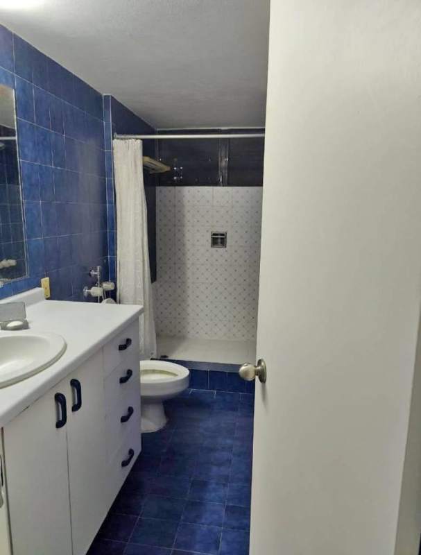 Minimalist bedroom with AC, built-in closet, white tile floors, blackout blinds in PH El Cangrejo Panama City