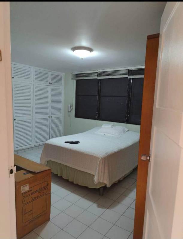 Contemporary living room tiled floor with green sofa and AC in PH El Cangrejo apartment rental Panama