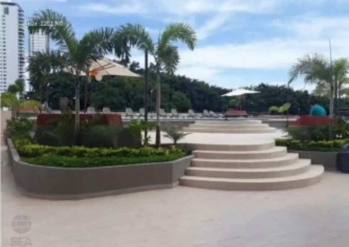 Resort-style swimming pool deck with lounge chairs and umbrellas at PH Sky Park Panama City