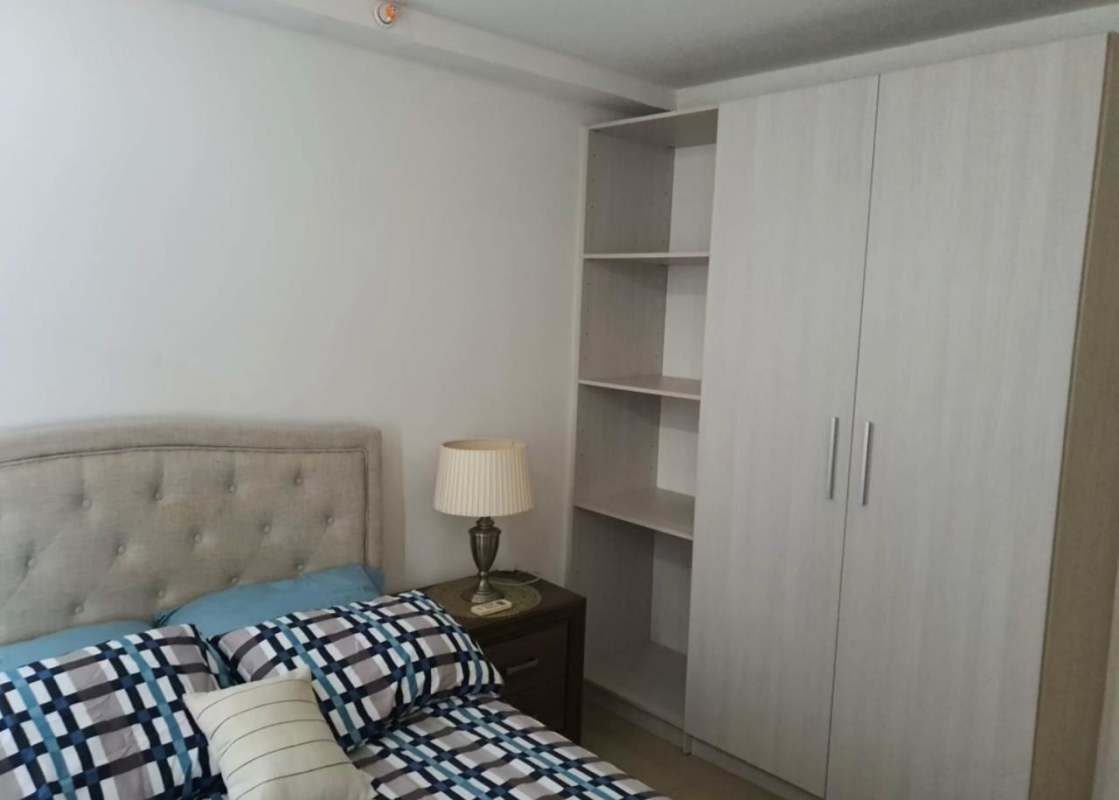 Bedroom in PH Sky Park apartment with built-in closet, AC, and window to Parque Omar
