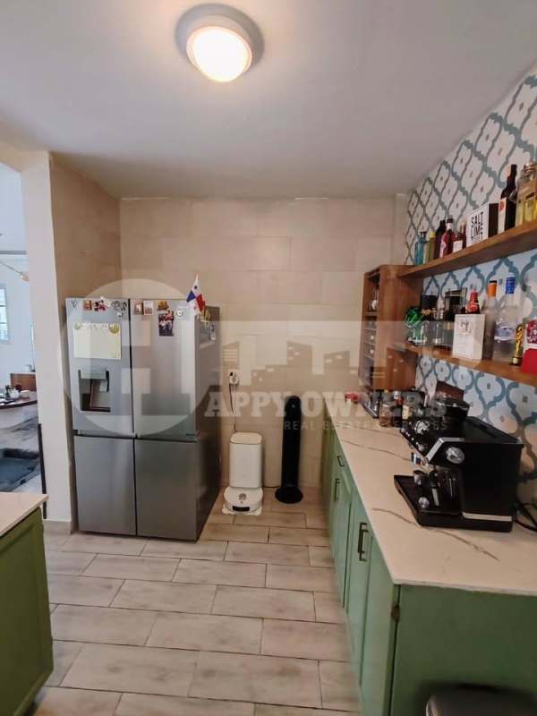 Kitchen with eclectic backsplash, green cabinetry, modern appliances Costa Sur Panama