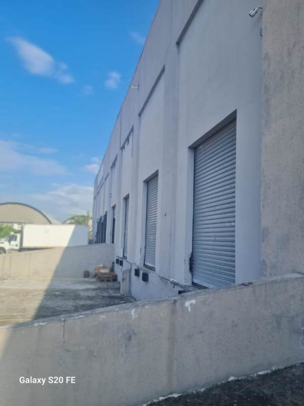 Exterior view of grey industrial warehouse building with multiple garage doors Pacora Panama
