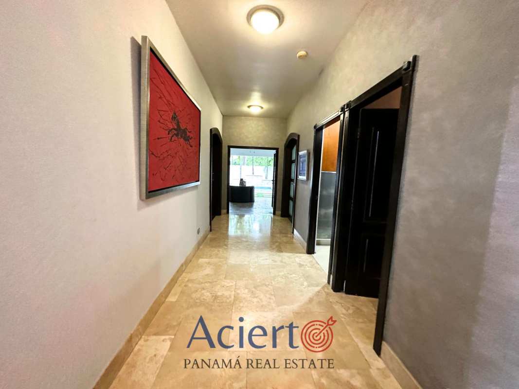 Elegant foyer with curved staircase, iron railing, and large feature window Residencial Antigua Panama